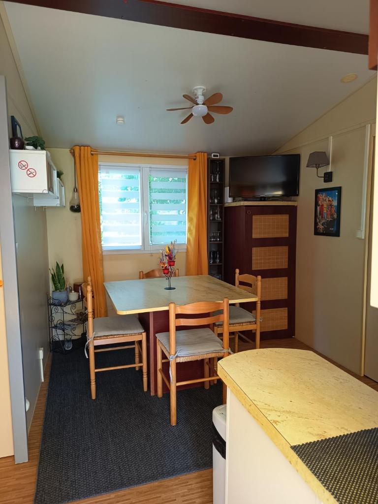 une salle à manger avec une table et des chaises et une fenêtre dans l'établissement Mobile home, à Quimper