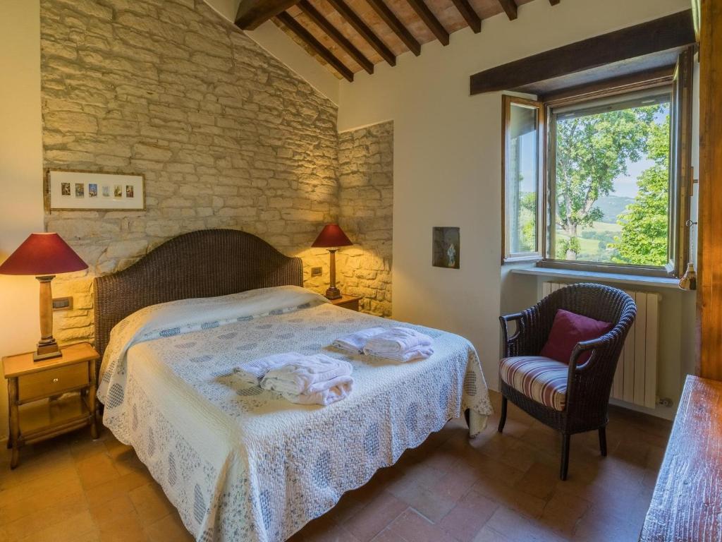 une chambre avec un lit, une chaise et une fenêtre dans l'établissement Scenic villa with heated pool, à SantʼIppolito