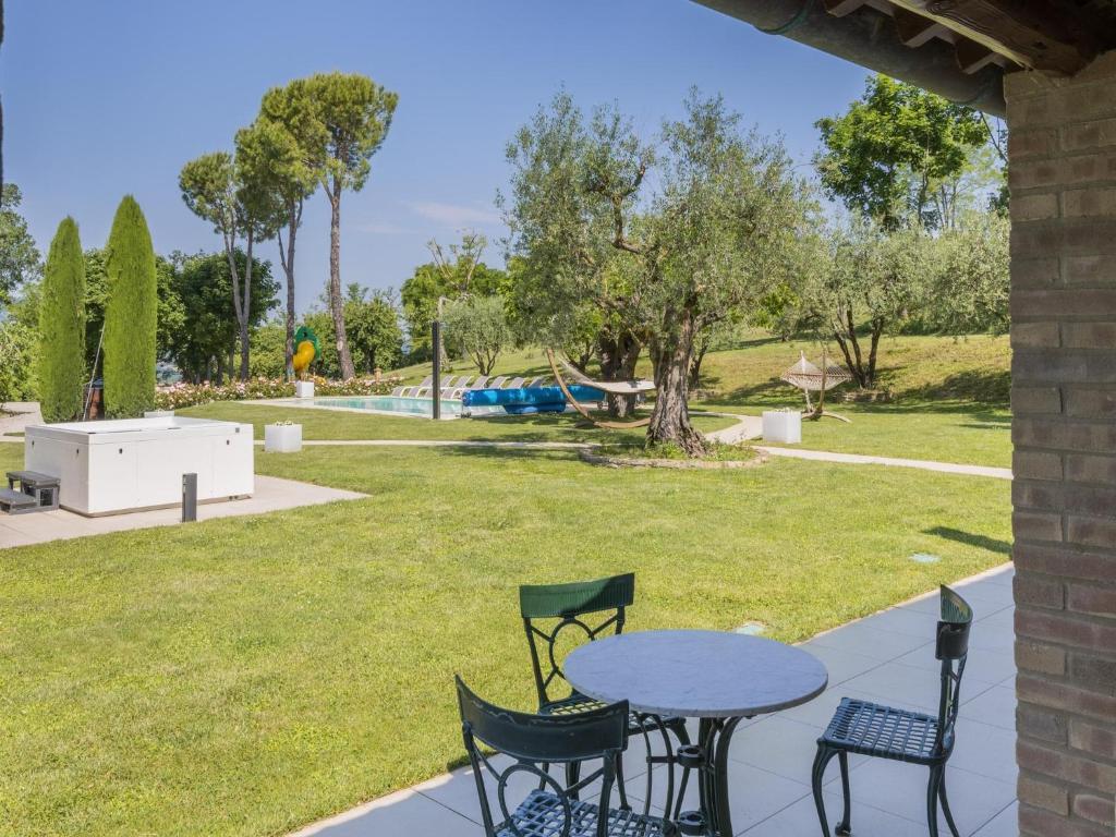 d'une terrasse avec une table, des chaises et un parc. dans l'établissement Scenic villa with heated pool, à SantʼIppolito
