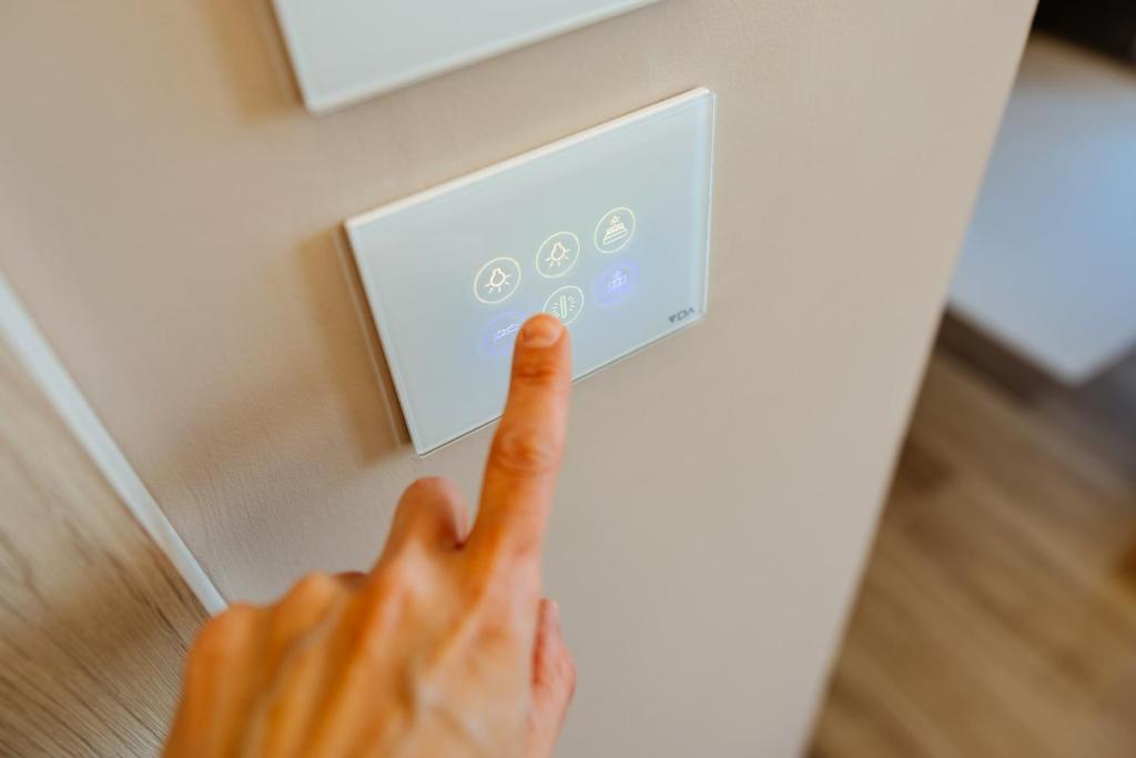 une main appuyant sur un bouton sur un mur dans l'établissement Wine Hotel Lugana Parco al Lago, à Sirmione