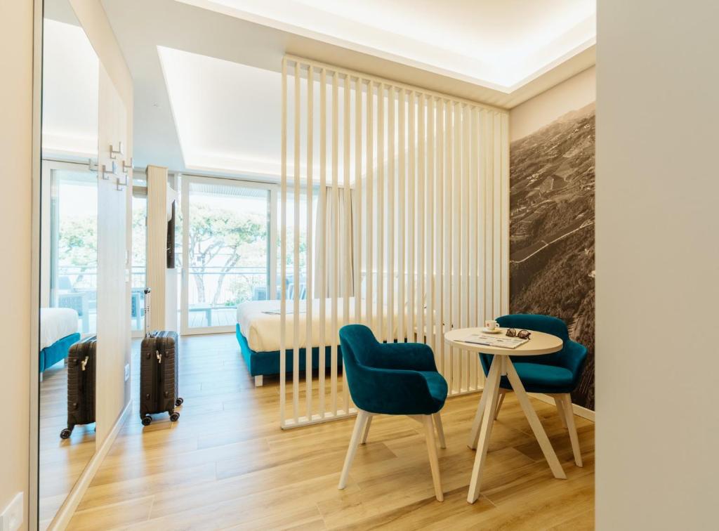 une chambre avec un lit, une table et des chaises dans l'établissement Wine Hotel Lugana Parco al Lago, à Sirmione