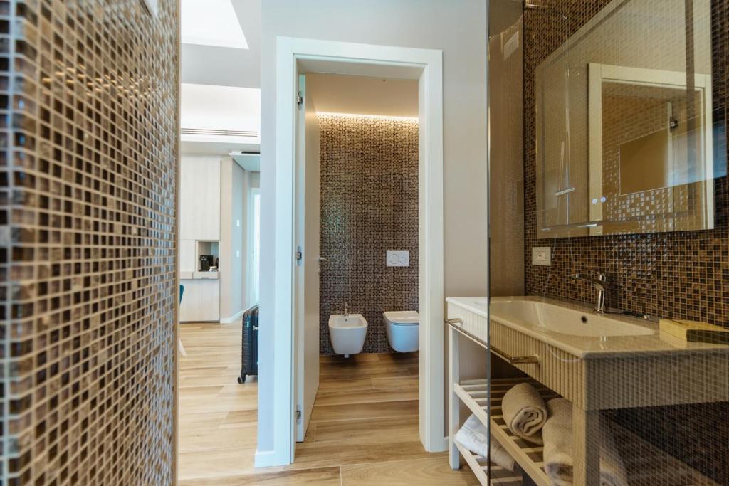 une salle de bain avec un lavabo et un miroir dans l'établissement Wine Hotel Lugana Parco al Lago, à Sirmione