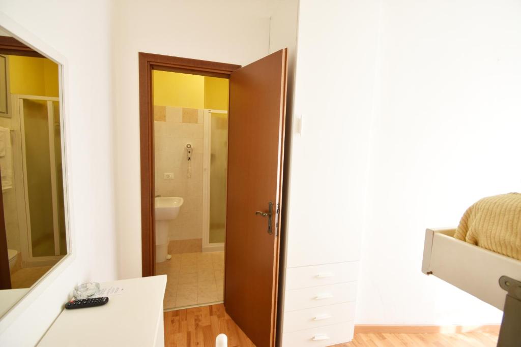 une chambre avec une salle de bain avec un placard et un miroir dans l'établissement Hotel Galles, à Lido di Jesolo
