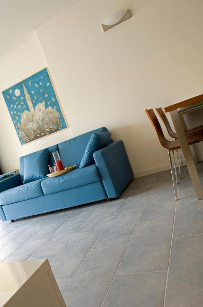 un canapé bleu dans un salon avec une table dans l'établissement Residence Hotel Hungaria, à Grado