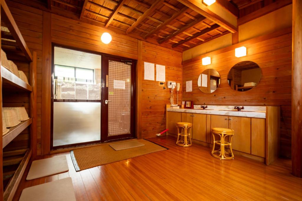 une salle de bain avec un lavabo et deux tabourets dans une pièce dans l'établissement Shimaya, à Yamanouchi