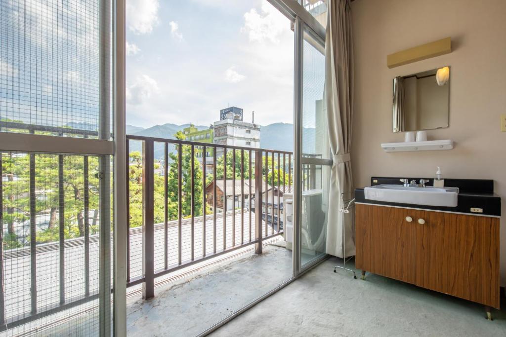 une salle de bain avec lavabo et un balcon dans l'établissement Shimaya, à Yamanouchi