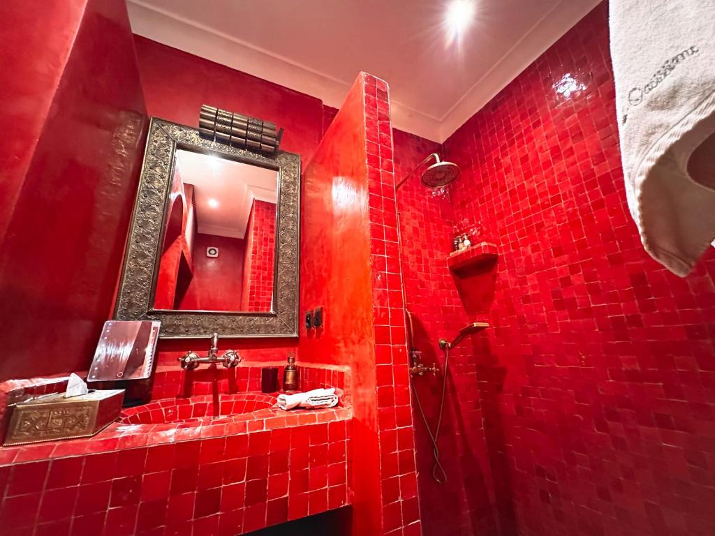 La salle de bains est pourvue de carrelage rouge, d'une douche et d'un miroir. dans l'établissement Riad Oasissime, à Marrakech 57 autres photos