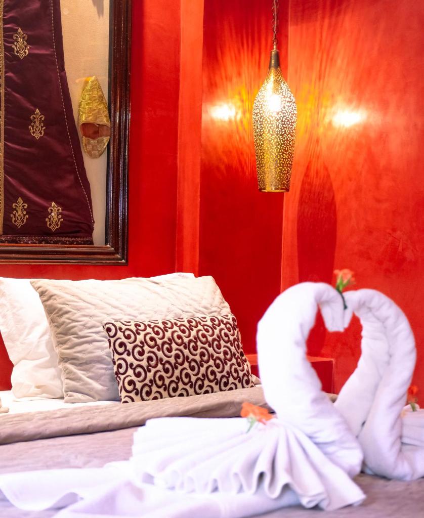 une chambre avec un lit décoré d'un cygne dans l'établissement Riad Oasissime, à Marrakech
