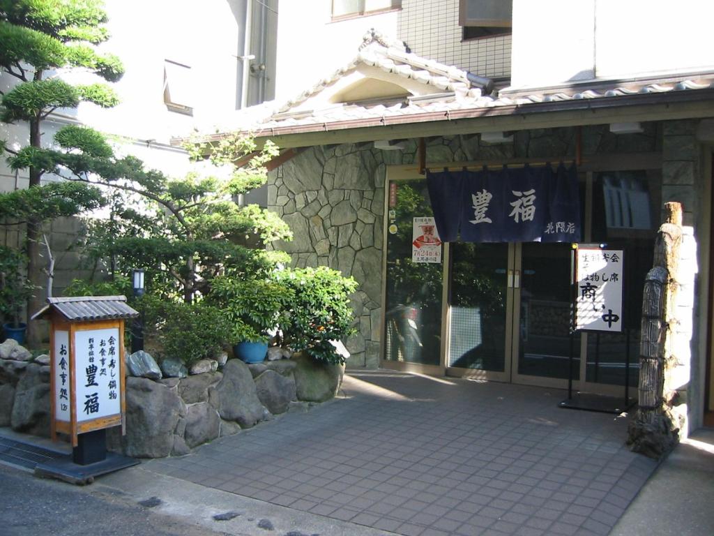 un bâtiment avec une enseigne devant lui dans l'établissement Toyofuku, à Kobe