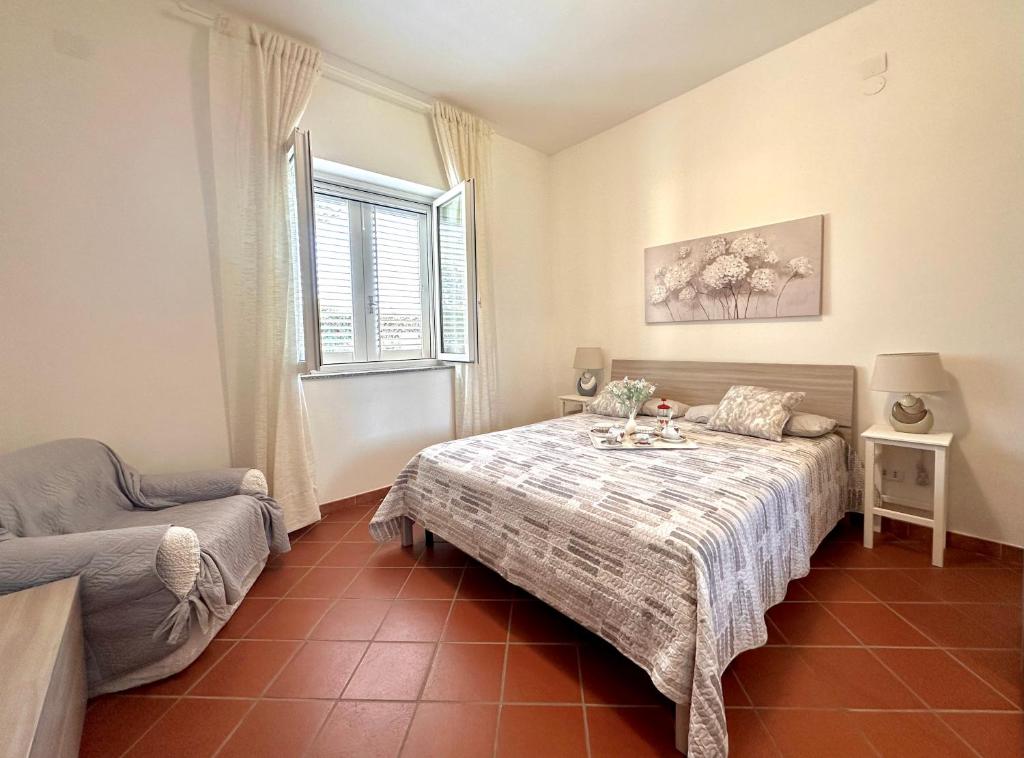 une chambre avec un lit, un canapé et une fenêtre dans l'établissement Rock Garden Villa by Ortigia Apartments, à Plemmirio
