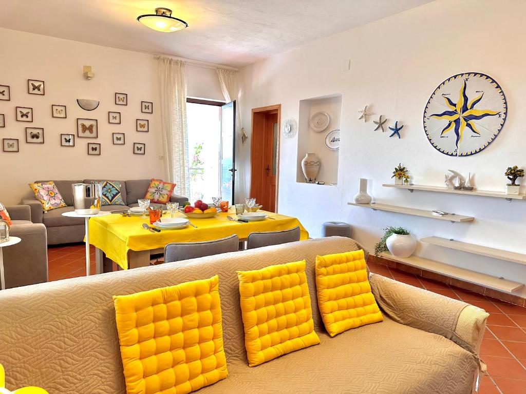 un salon avec un canapé jaune et une table dans l'établissement Rock Garden Villa by Ortigia Apartments, à Plemmirio