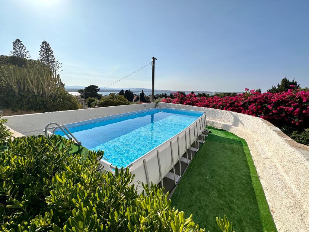 - une piscine au milieu d'un jardin fleuri dans l'établissement Rock Garden Villa by Ortigia Apartments, à Plemmirio