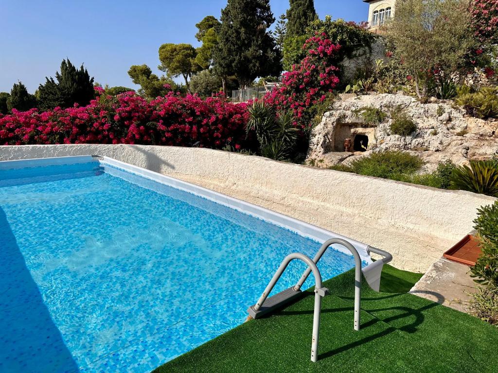 une piscine dans une cour fleurie dans l'établissement Rock Garden Villa by Ortigia Apartments, à Plemmirio 22 autres photos