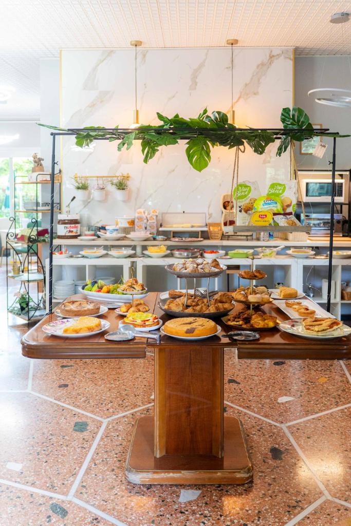 un buffet avec de nombreuses assiettes de nourriture sur une table dans l'établissement Hotel Capri, à Rimini 74 autres photos