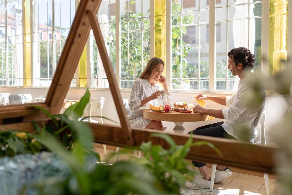 deux femmes assises à une table en train de manger dans l'établissement Ausonia Hungaria Wellness & Lifestyle, sur le Lido de Venise