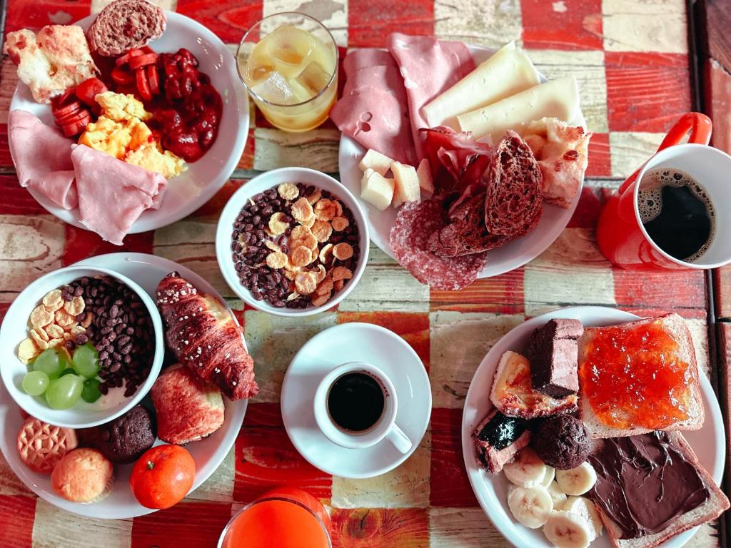 une table avec des assiettes de nourriture et des tasses de café dans l'établissement Hotel Bello by Ostello Bello, à Finale Ligure