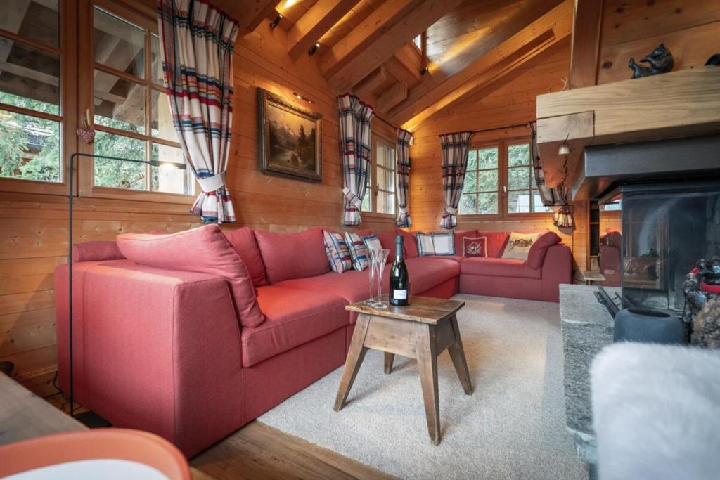 un salon avec un canapé rouge et une cheminée dans l'établissement Chalet Joseph, à Courchevel