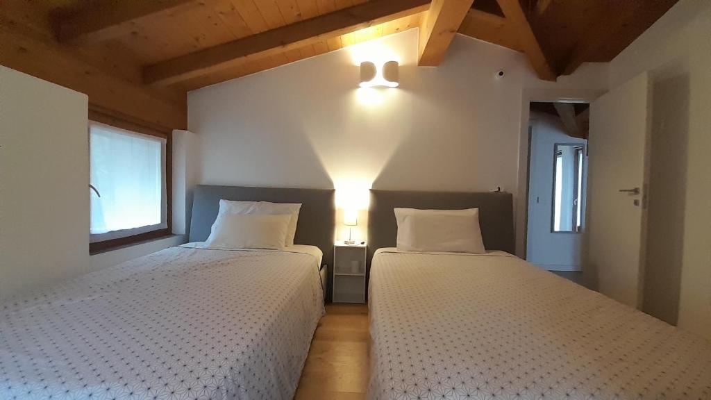 - 2 lits dans une chambre avec 2 lampes murales dans l'établissement Holiday Home Villa Salici, pool & garden, à Colico 31 autres photos