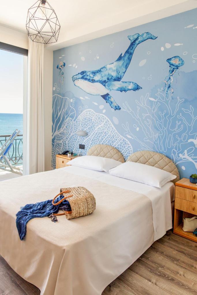 une chambre avec un grand lit avec un mur bleu dans l'établissement Hotel Golfo e Palme, à Diano Marina