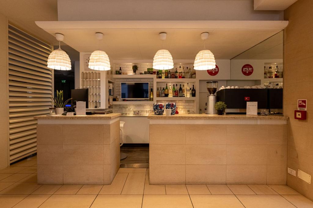 un bar dans un restaurant avec des lampes suspendues dans l'établissement Hotel Villa Edda, à Riccione