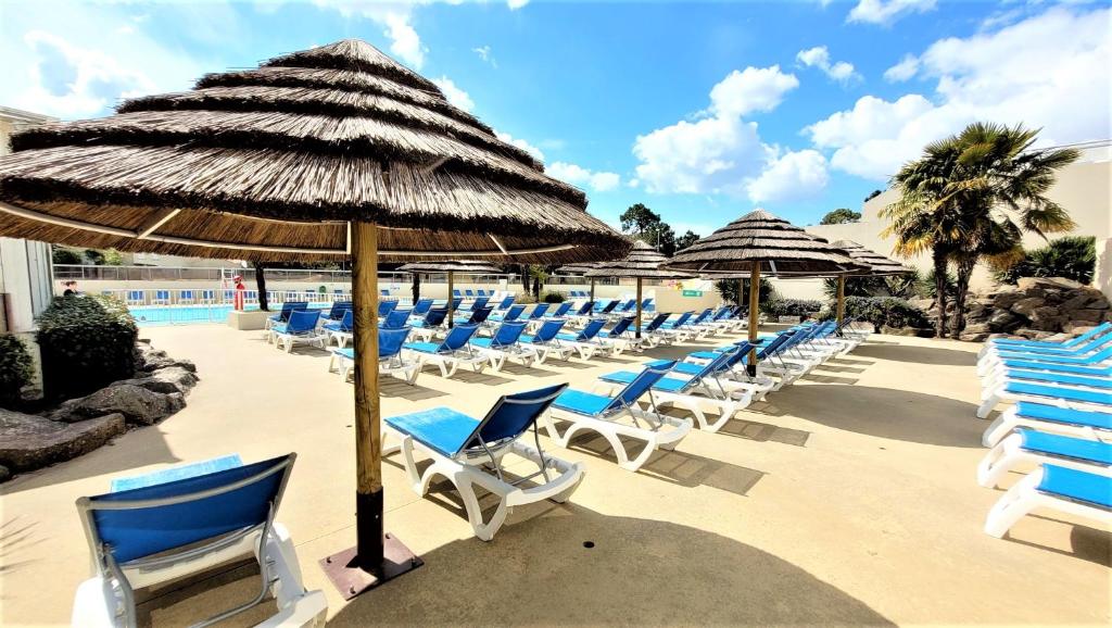 - un bouquet de chaises et de parasols sur une plage dans l'établissement Mobil-homes proche de l'océan, à Saint-Jean-de-Monts