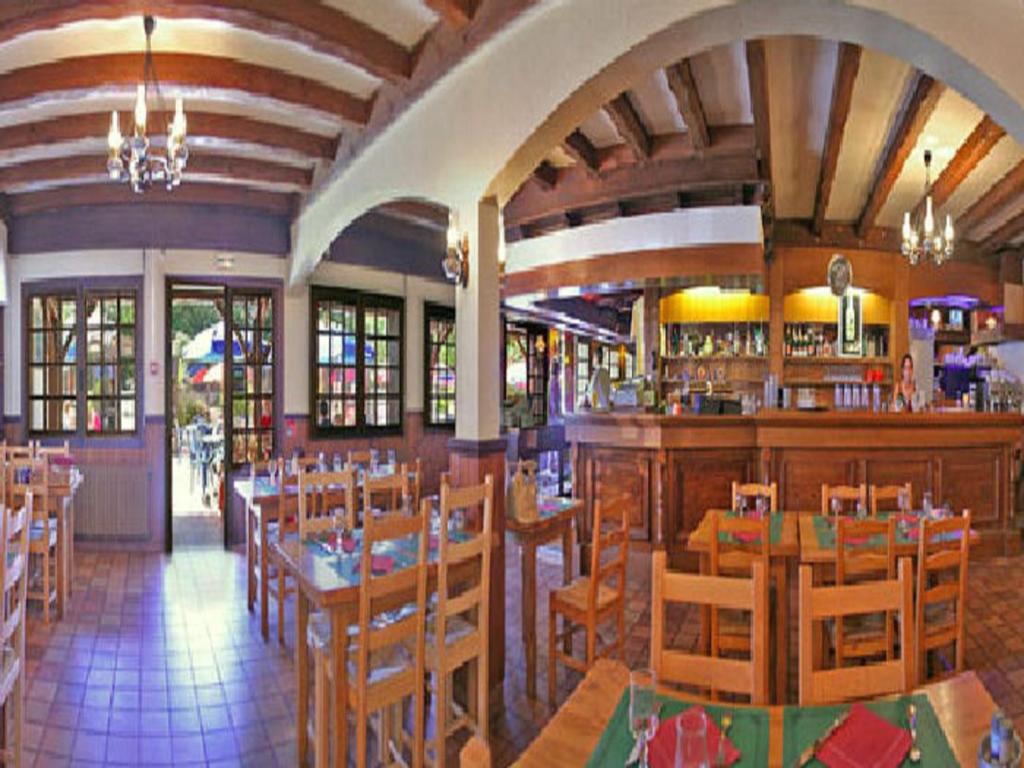 un restaurant avec des tables et des chaises et un bar dans l'établissement Mobil-homes proche de l'océan, à Saint-Jean-de-Monts