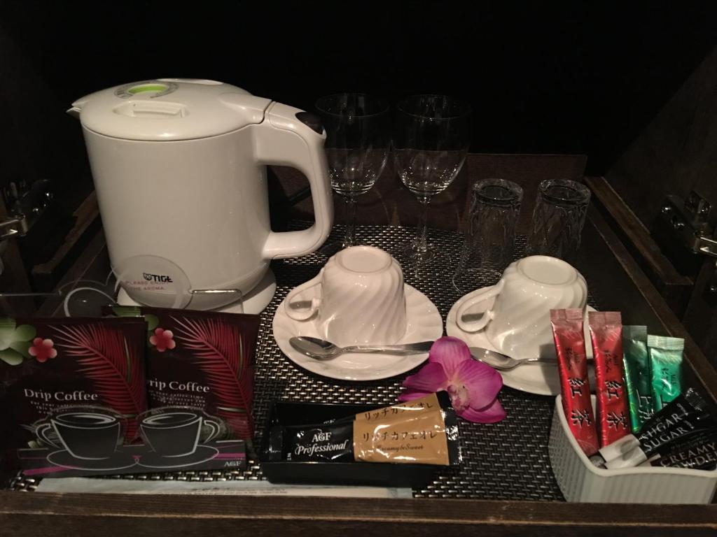 une table avec une cafetière, des assiettes et des verres dans l'établissement Hotel W-BAGUS -W GROUP HOTELS and RESORTS-, à Tokyo