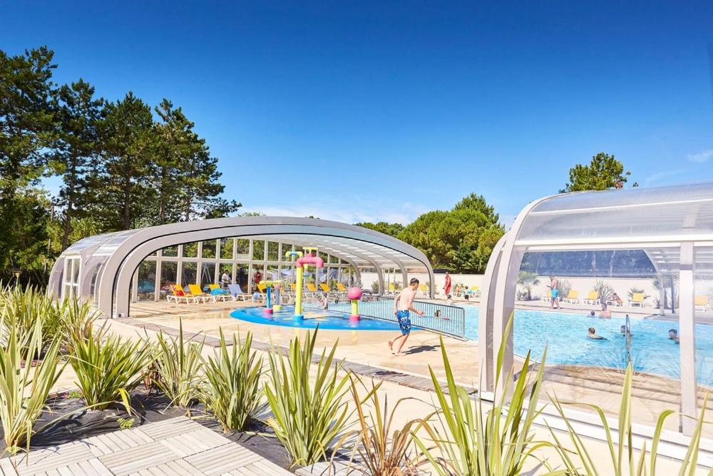 une décoration architecturale d'une piscine avec des gens qui y vivent dans l'établissement Mobil home proche du paradis des plages, à Saint-Jean-de-Monts