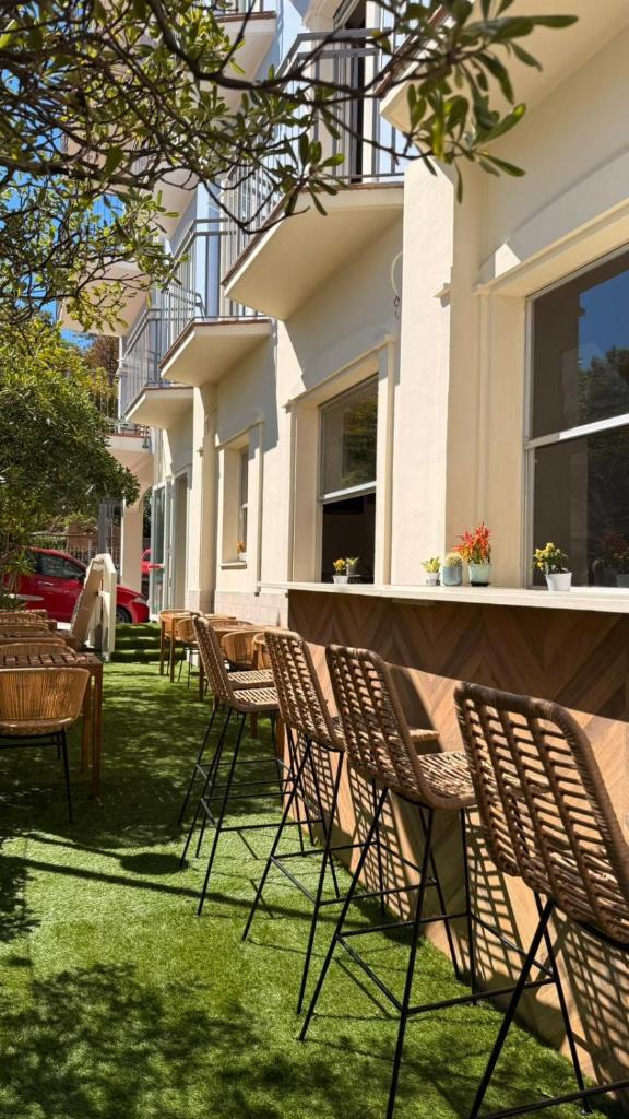 un groupe de chaises et de tables devant un bâtiment dans l'établissement Rock Crystal Boutique Hotel, à Gabicce Mare