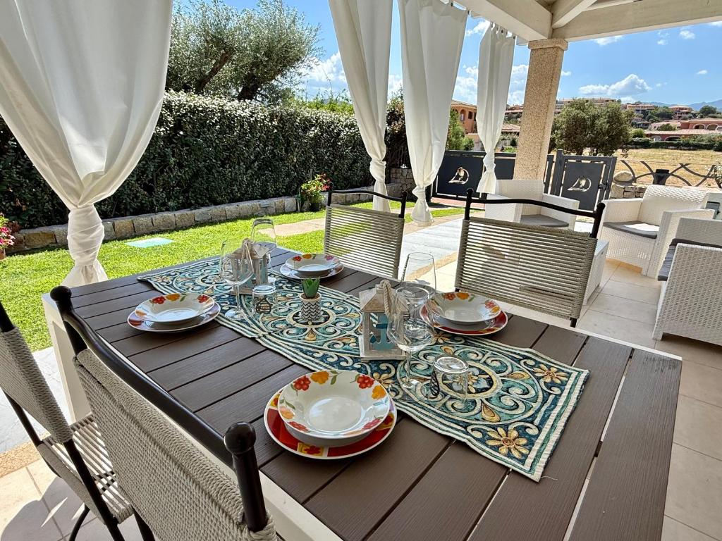 - une table en bois avec des assiettes et de la vaisselle dans l'établissement VILLA AQUA LUXURY Private Pool, à San Teodoro