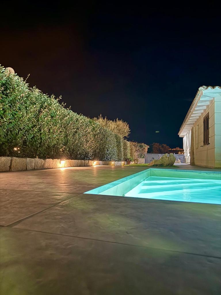 - une piscine avec une maison la nuit dans l'établissement VILLA AQUA LUXURY Private Pool, à San Teodoro