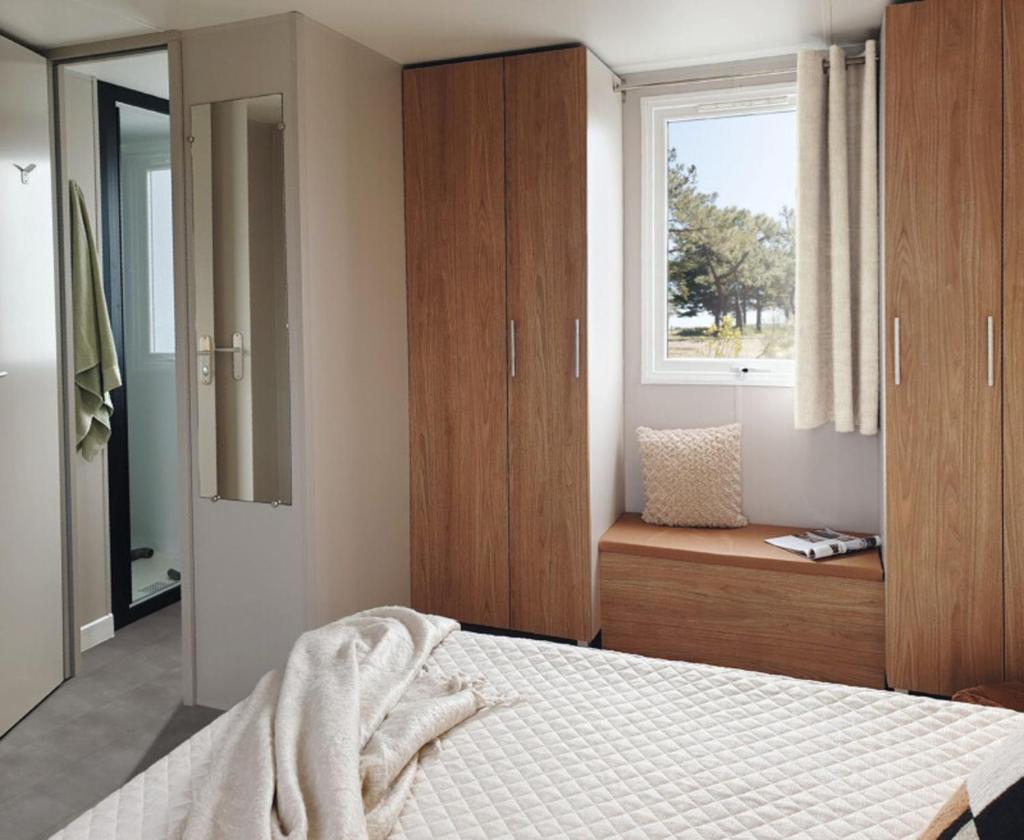 une chambre avec un lit et une fenêtre dans l'établissement mobil home Piriac 2 chambres 4 à 6 pers, à Piriac-sur-Mer 22 autres photos