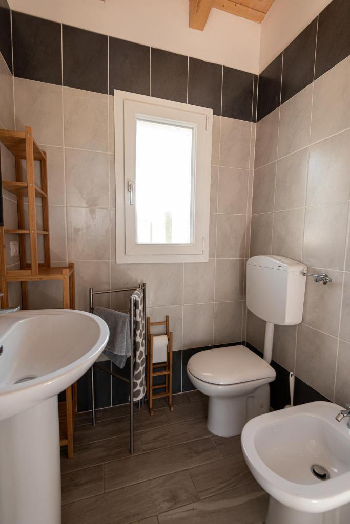 une salle de bain avec un lavabo et des toilettes et une fenêtre dans l'établissement La Rondine, à Calambrone