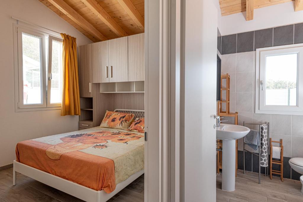 une chambre avec un lit et un lavabo dans l'établissement La Rondine, à Calambrone