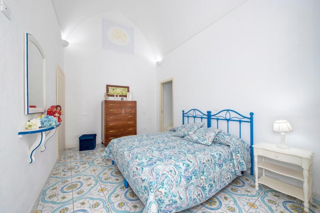 - une chambre avec un lit bleu et une commode dans l'établissement Wonderful villa with swimming pool overlooking the sea, 200 steps from the road, à Conca dei Marini