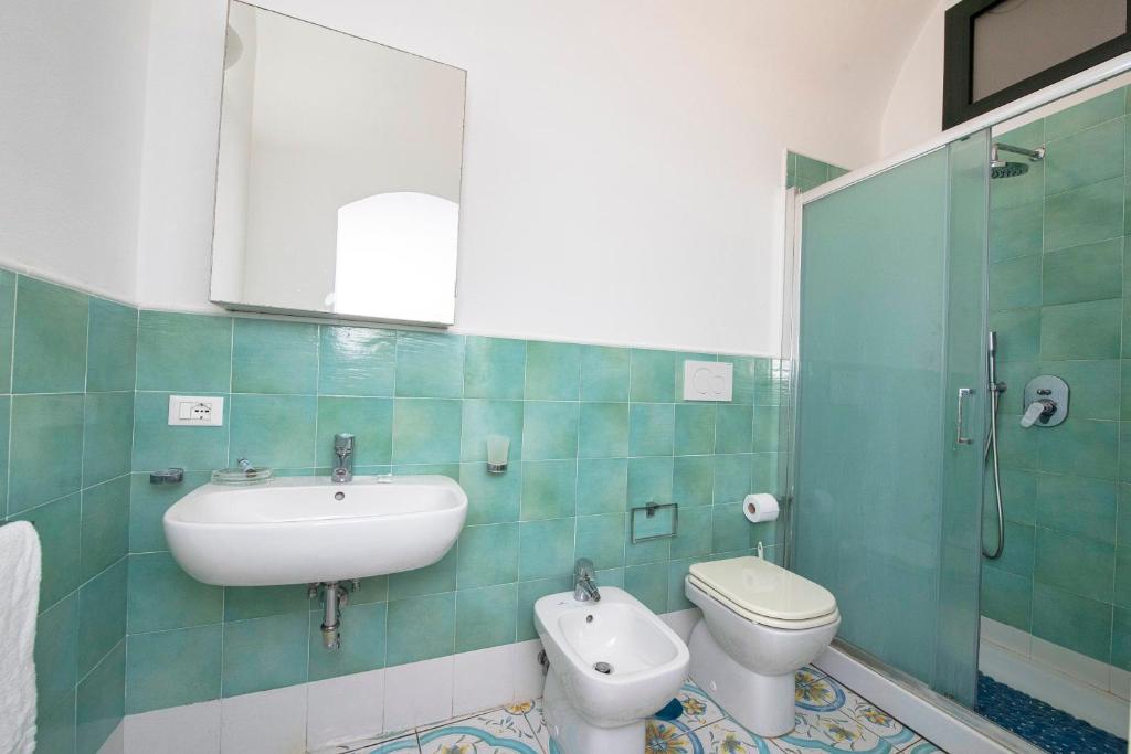 une salle de bain avec un lavabo, des toilettes et un miroir dans l'établissement Wonderful villa with swimming pool overlooking the sea, 200 steps from the road, à Conca dei Marini