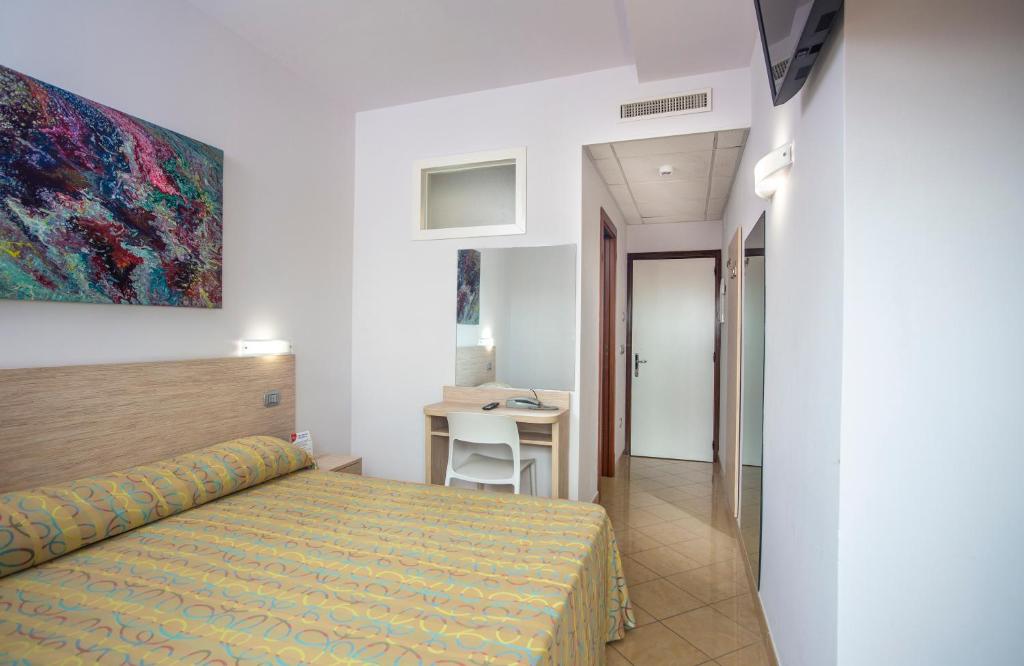 une chambre d'hôtel avec un lit et un bureau dans l'établissement Hotel Palace Magnolia SPA, à Tortoreto Lido
