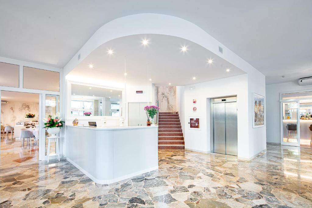une grande pièce avec un comptoir et un escalier dans l'établissement Hotel Centrale, à Lignano Sabbiadoro