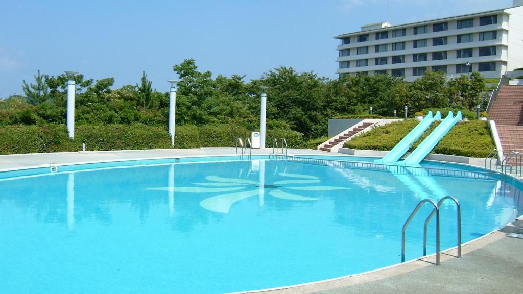 une grande piscine bleue avec toboggan dans l'établissement Ryoso Uminocho, à Ise