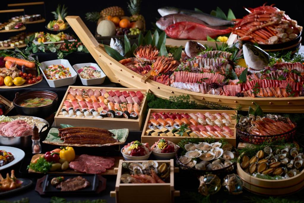 un buffet de différents types de nourriture sur une table dans l'établissement Ooedo Onsen Monogatari Premium Shirahama Saichoraku, à Shirahama