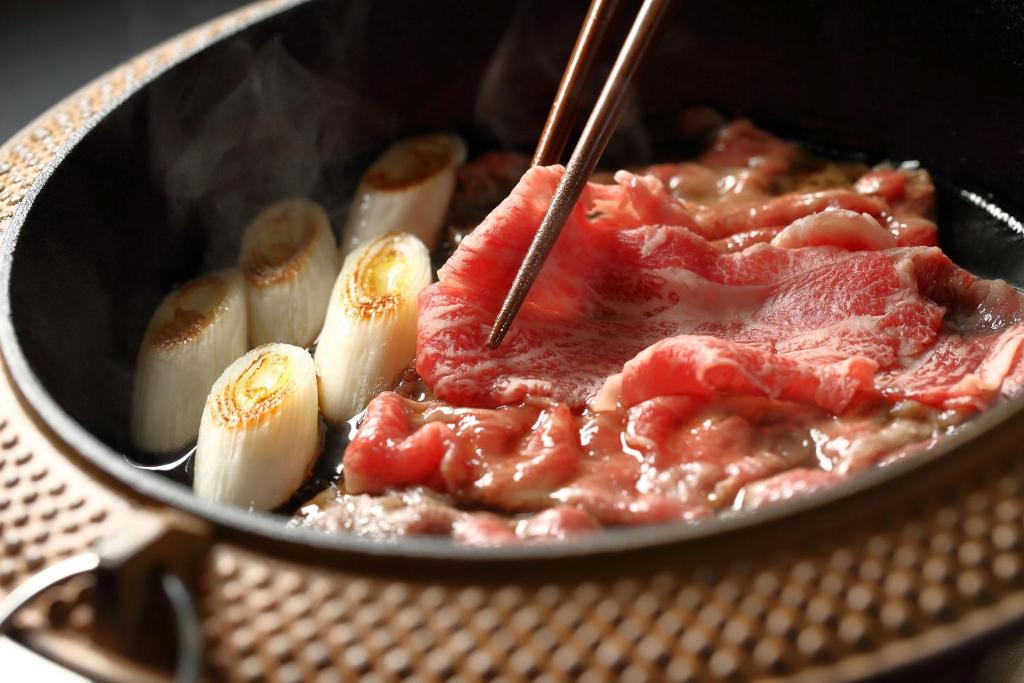 un pot alimentaire contenant de la viande et des légumes dans l'établissement Ooedo Onsen Monogatari Premium Shirahama Saichoraku, à Shirahama