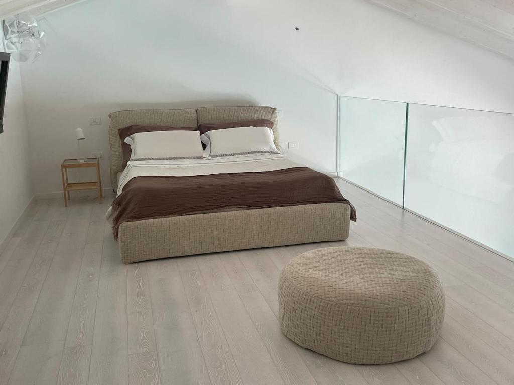 - une chambre avec un grand lit et un pouf dans l'établissement Luxury Loft Ai 2 lecci Relaxing oasis with pool, à Cadoneghe 26 autres photos