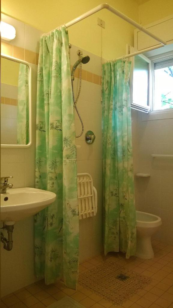 une salle de bain avec un rideau de douche et un lavabo dans l'établissement Hotel Capri, à Rimini