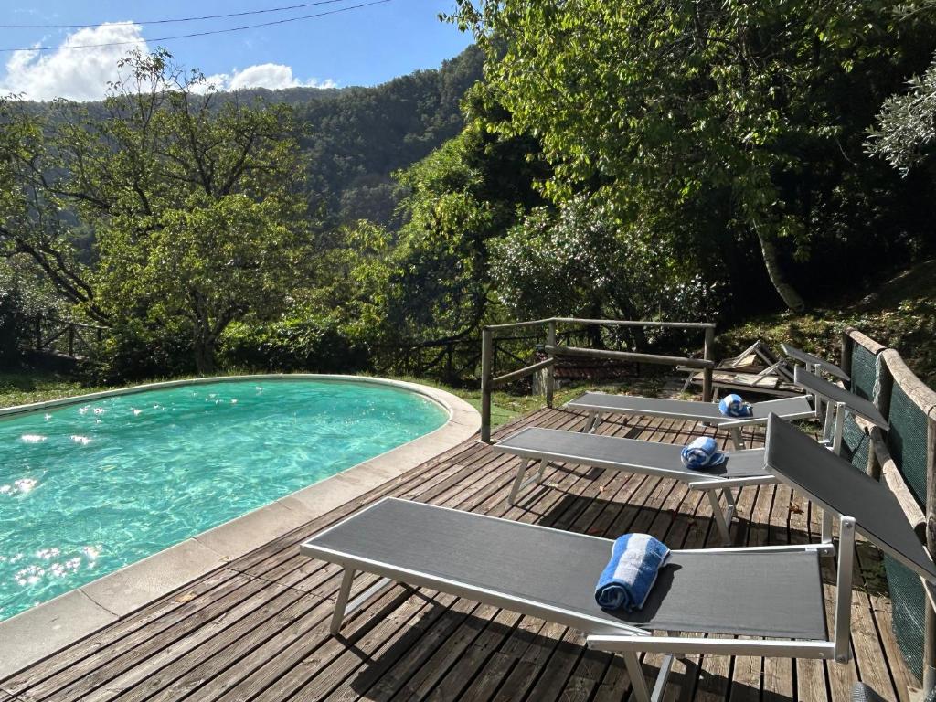 - une piscine sur une terrasse en bois avec 2 chaises longues dans l'établissement Casa Visconti, à Bolognana