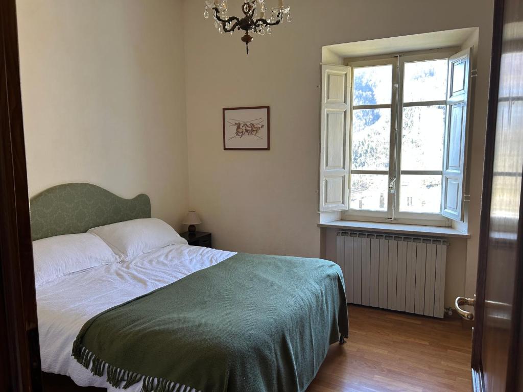 une chambre avec un lit et une fenêtre dans l'établissement Casa Visconti, à Bolognana