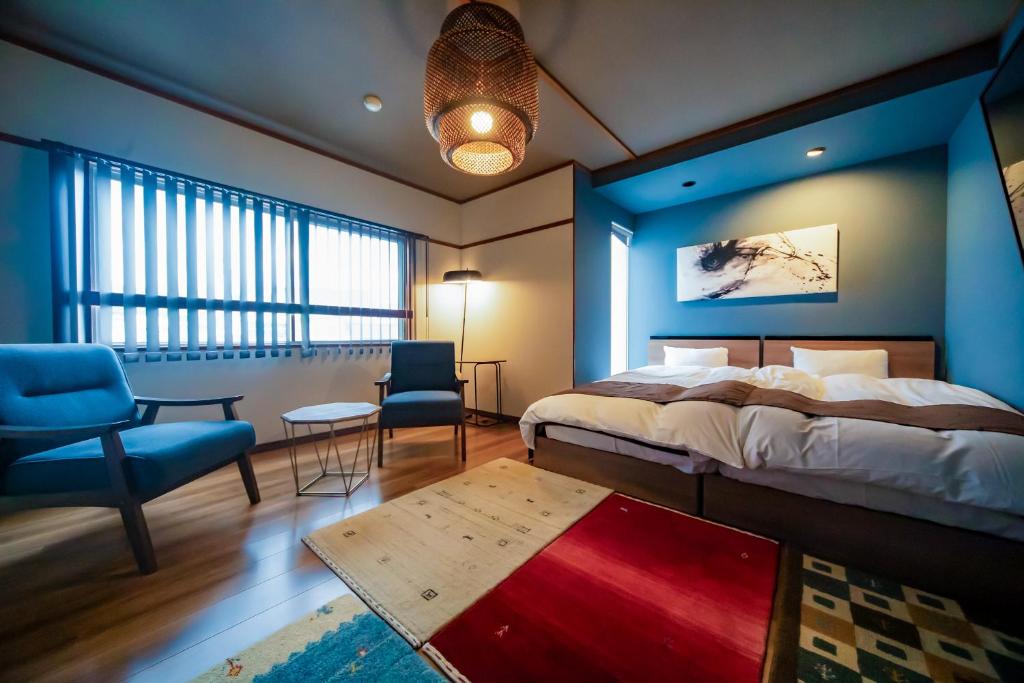 une chambre avec un lit et un mur bleu dans l'établissement Kunisakisou, à Beppu