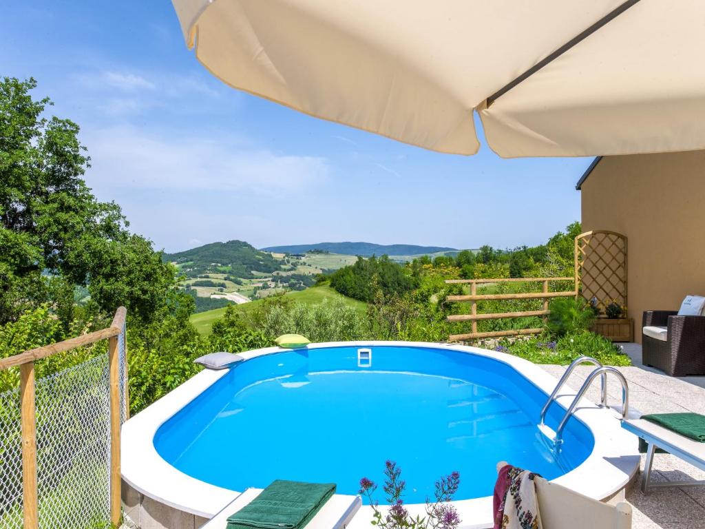 - une grande piscine bleue sur une terrasse avec un parasol dans l'établissement Serene Villa, Peaceful Pergola, à Pergola