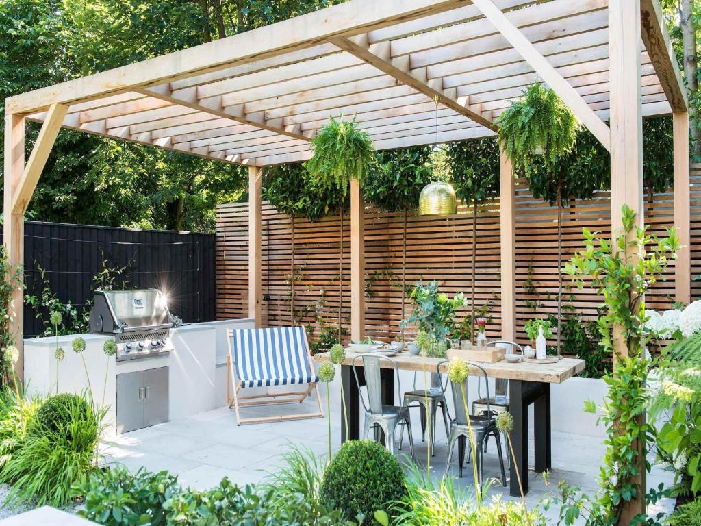 un patio avec une pergola en bois et une table et des chaises dans l'établissement Serene Villa, Peaceful Pergola, à Pergola 24 autres photos