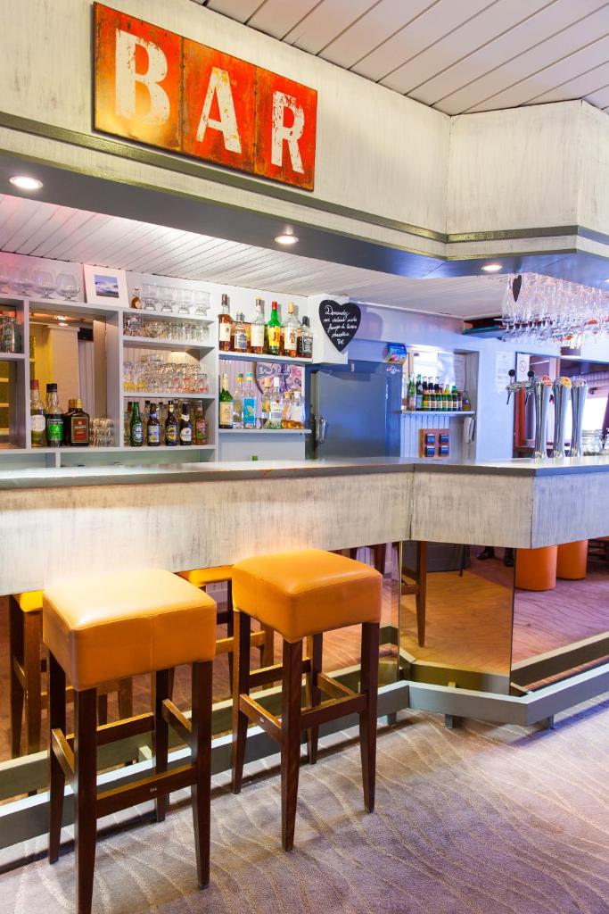 un bar dans un restaurant avec tabourets orange dans l'établissement Hôtel La Vanoise, à Tignes