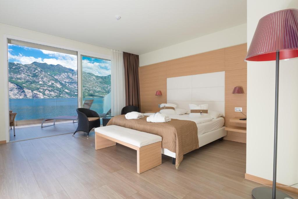 une chambre avec un lit et une grande fenêtre dans l'établissement Hotel Castello Lake Front, à Malcesine